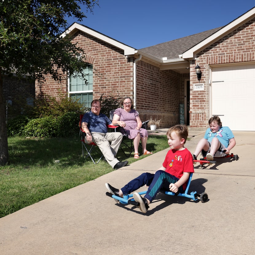Samuel and Abigail Owens look on as 6-year-old Oren and 10-year-old Micah play outside their...