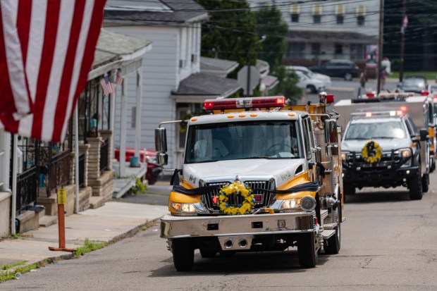 Firetrucks take part in a funeral procession for Thomas J....