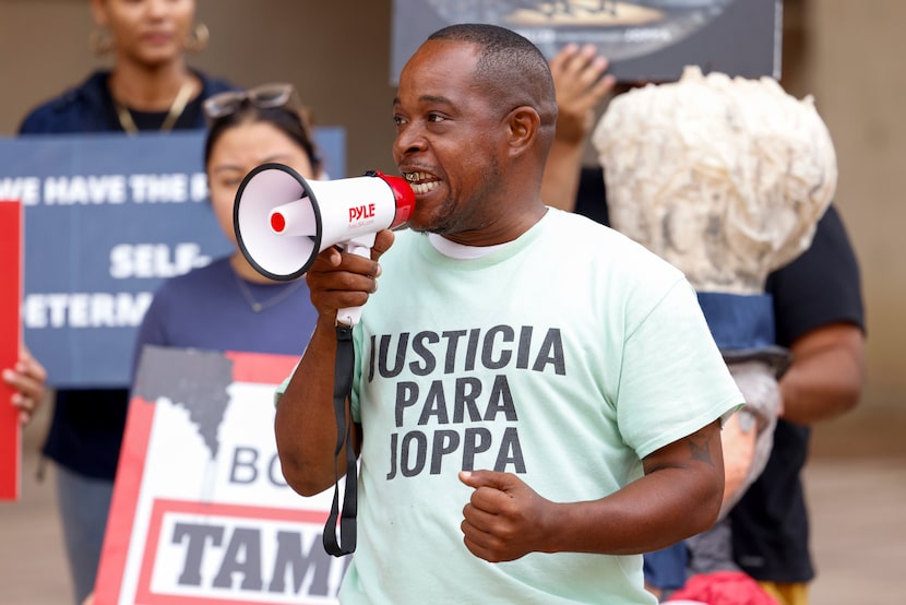 Emmanuel Davis of Justice for Joppa speaks into a megaphone during a news conference to...