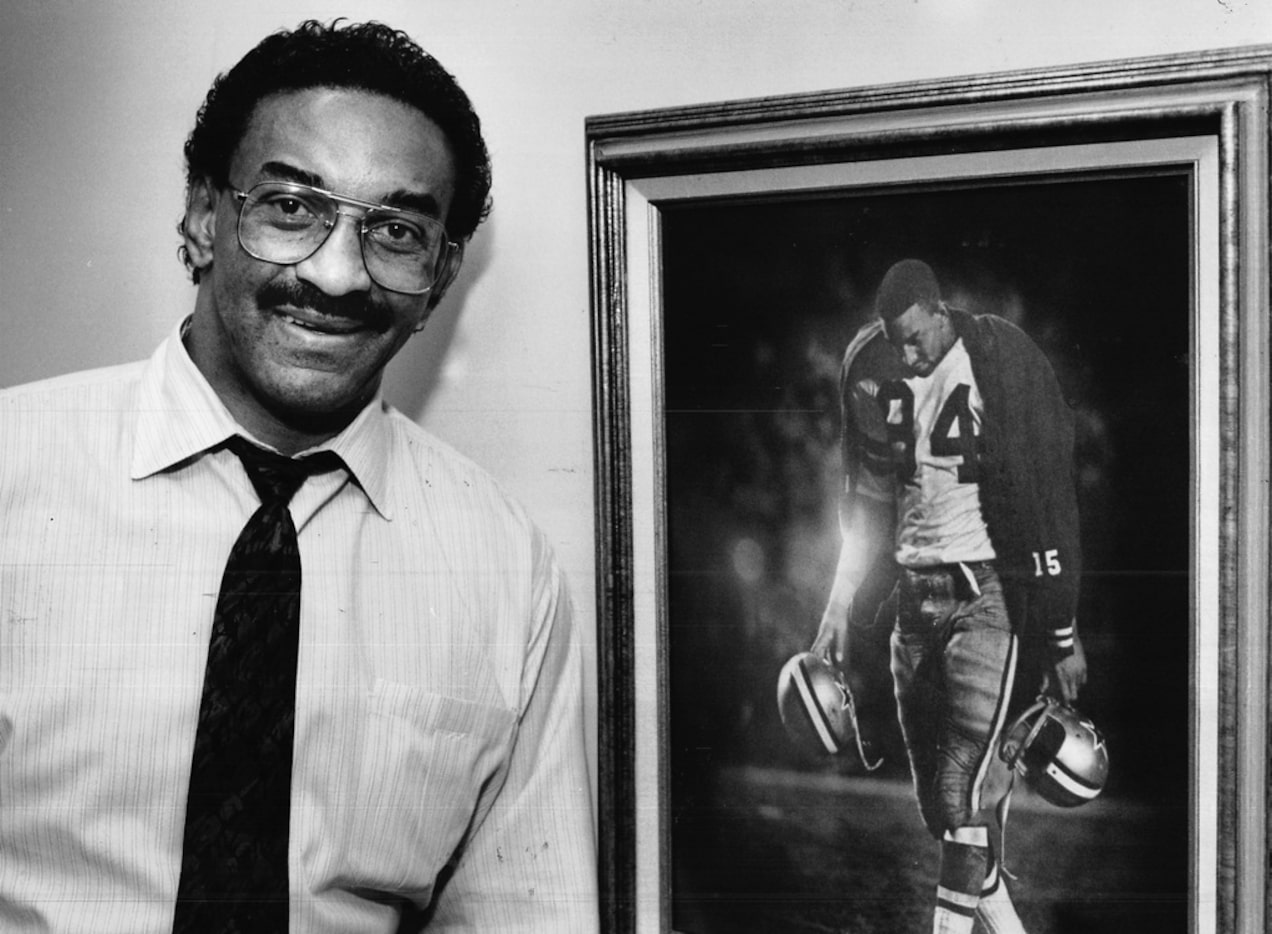 In a 1988 photo, former Dallas Cowboys Pettis Norman stands next to a picture of himself...