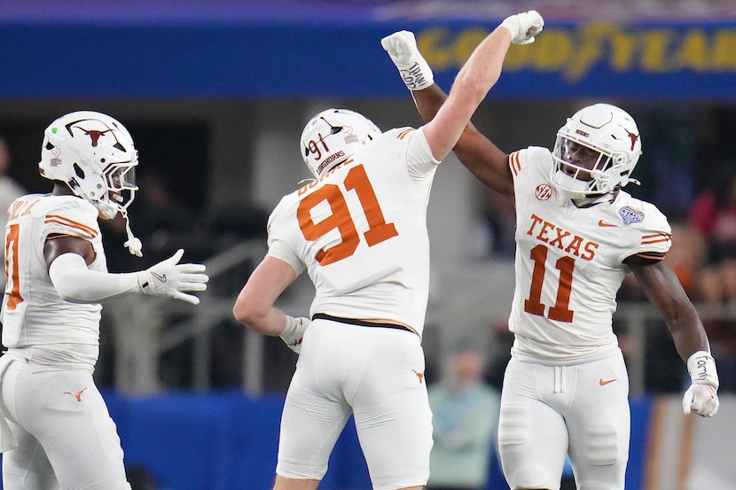 Texas linebacker Colin Simmons (11) celebrates with linebacker Ethan Burke (91) and...