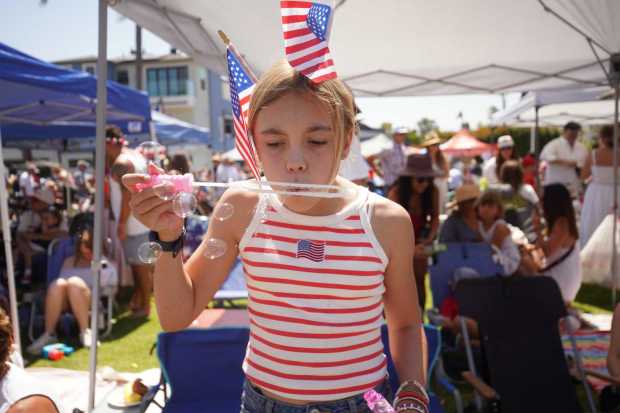 ....Blaire Kerns makes bubbles at Orange Ave during the parade on Friday, July 4, 2025 in Coronado, CA. (Michael Ho / The San Diego Union-Tribune)