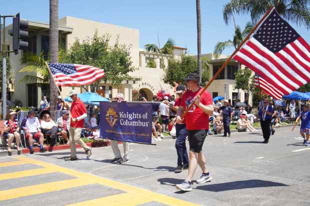 ....People from the Knights of Columbus march at Orange Ave during the parade on Friday, July 4, 2025 in Coronado, CA. (Michael Ho / The San Diego Union-Tribune)