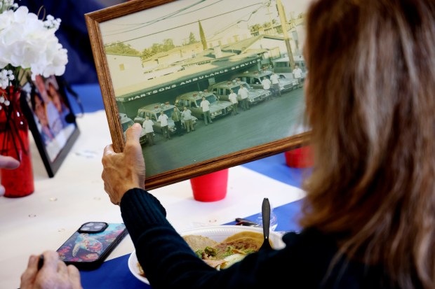 A guest overlooks a photo from 1971 when Gordon Anderson worked with Hartson's Ambulance Service during a retirement celebration at the VFW Hall in La Mesa on Friday, July 18, 2025. (Sandy Huffaker / For The San Diego Union-Tribune)
