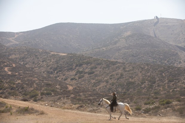 U.S. Border Patrol agents rides a horse near the U.S.-Mexico border walls on Thursday, June 26, 2025 in Otay Mesa, California. Agents have used horses since the agency was created but paused in 2023. The program was resurrected in March and the unit consists of 12 horses. (Ana Ramirez / The San Diego Union-Tribune)