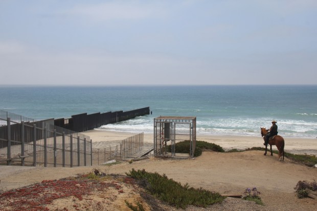 A U.S. Border Patrol agent stands near Friendship Park on the U.S.-Mexico border in 2012. (María Teresa Fernández)