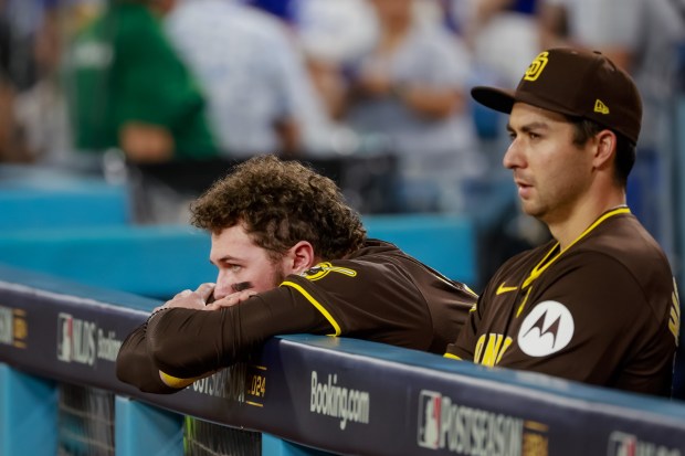 San Diego Padres Jackson Merrill, left, and Kyle Higashioka watch on-field celebrations as the Los Angeles Dodgers beat the Padres to win Game 5 of the NLDS at Dodger Stadium on Friday, Oct. 11, 2024. (Photo by K.C. Alfred / The San Diego Union-Tribune)