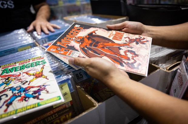 Richard Guevara, a comics collector, picks up a classic Avengers comic he's been searching for at the San Diego Comic-Con on Thursday, July 24, 2025 in San Diego, California. (Ana Ramirez / The San Diego Union-Tribune)