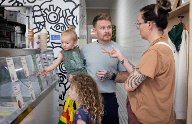 Sam Rodriguez, middle, a lieutenant junior grade and medical corps officer for the U.S. Navy, talks with their wife Via about what flavors of ice cream to get with their children at Stella Jean's on Wednesday, July 2, 2025 in San Diego. (Ana Ramirez / The San Diego Union-Tribune)