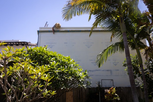 A worker finishes painting an ADU on Tuesday, July 29, 2025 in San Diego. (Ana Ramirez / The San Diego Union-Tribune)