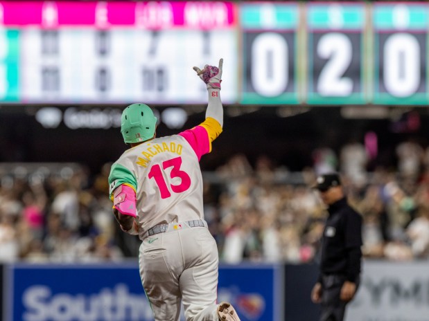 San Diego Padres' Manny Machado holds up his right hand as he runs the bases after hitting a home run in the ninth inning of a baseball game against the Kansas City Royals, Friday, June 20, 2025, in San Diego. (AP Photo/Tony Ding)
