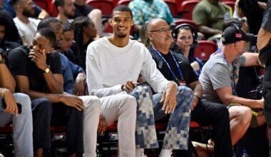 San Antonio Spurs' Victor Wembanyama, center, sits court side during the first half of an NBA summer league basketball game between the Spurs and Philadelphia 76ers, Thursday, July 10, 2025, in Las Vegas. (AP Photo/David Becker)
