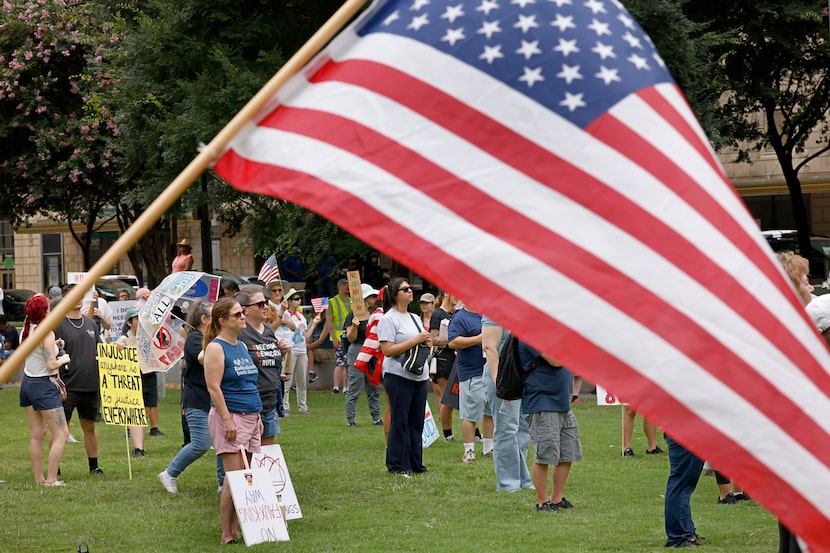 People attend a protest hosted by 50501 and Indivisible at Main Street Garden, Friday, July...