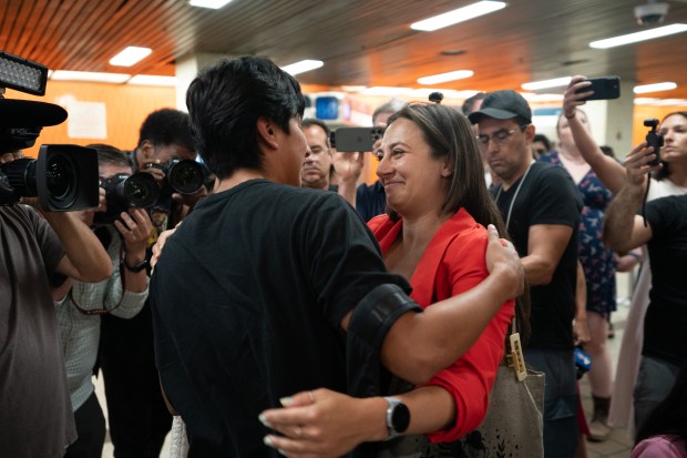 Queens high school student Derlis Chusin is greeted by NYLAG attorney Rebecca Rubin after he walked off a bus at the Port Authority Bus Terminal on Friday. 