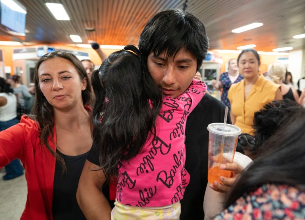 Queens high school student Derlis Snaider Chusin Toaquiza hugs a young relative at the Port Authority Bus Terminal after returning to New York on a bus after being released from ICE custody in Texas on Friday.