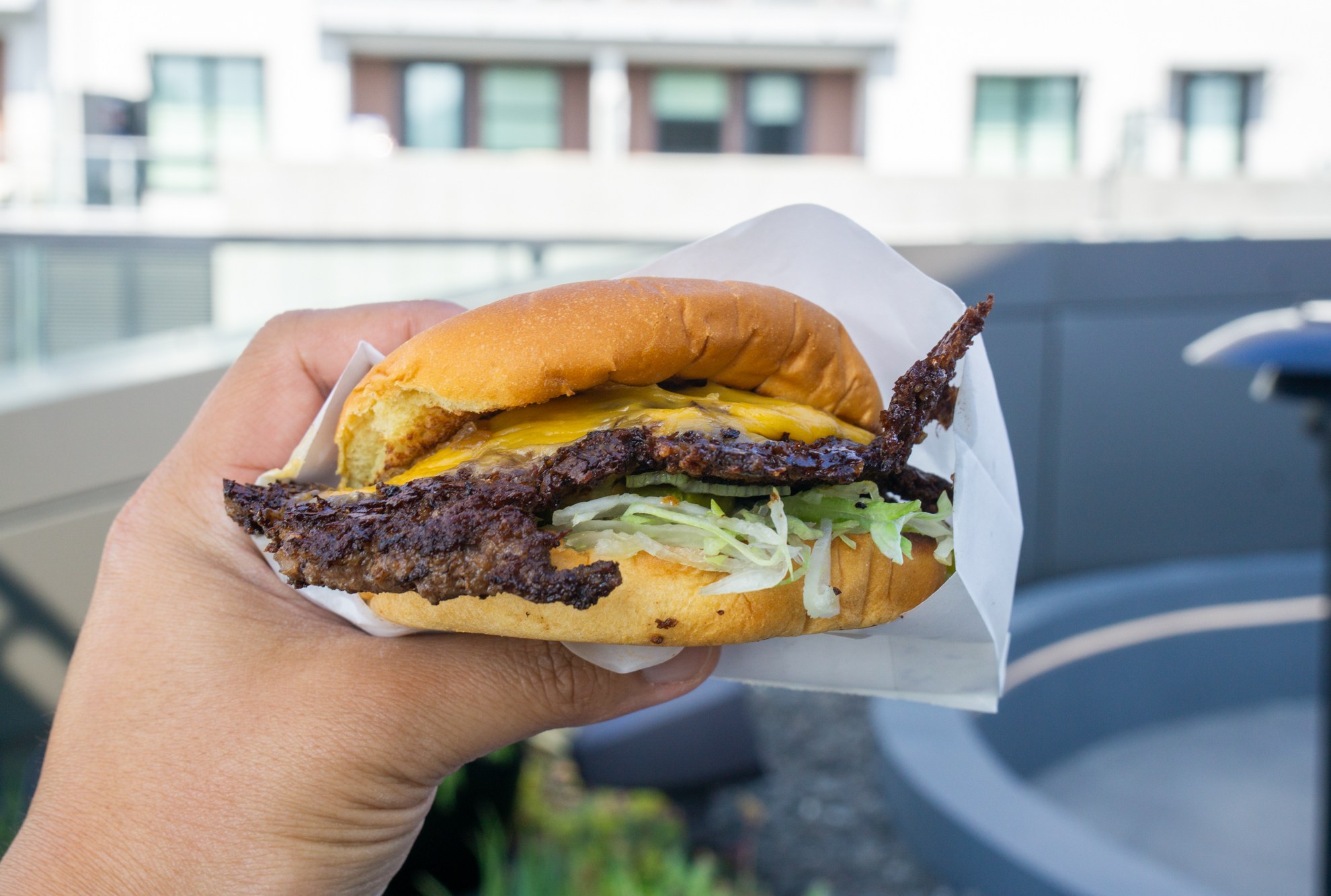 Cheeseburger held in hand.