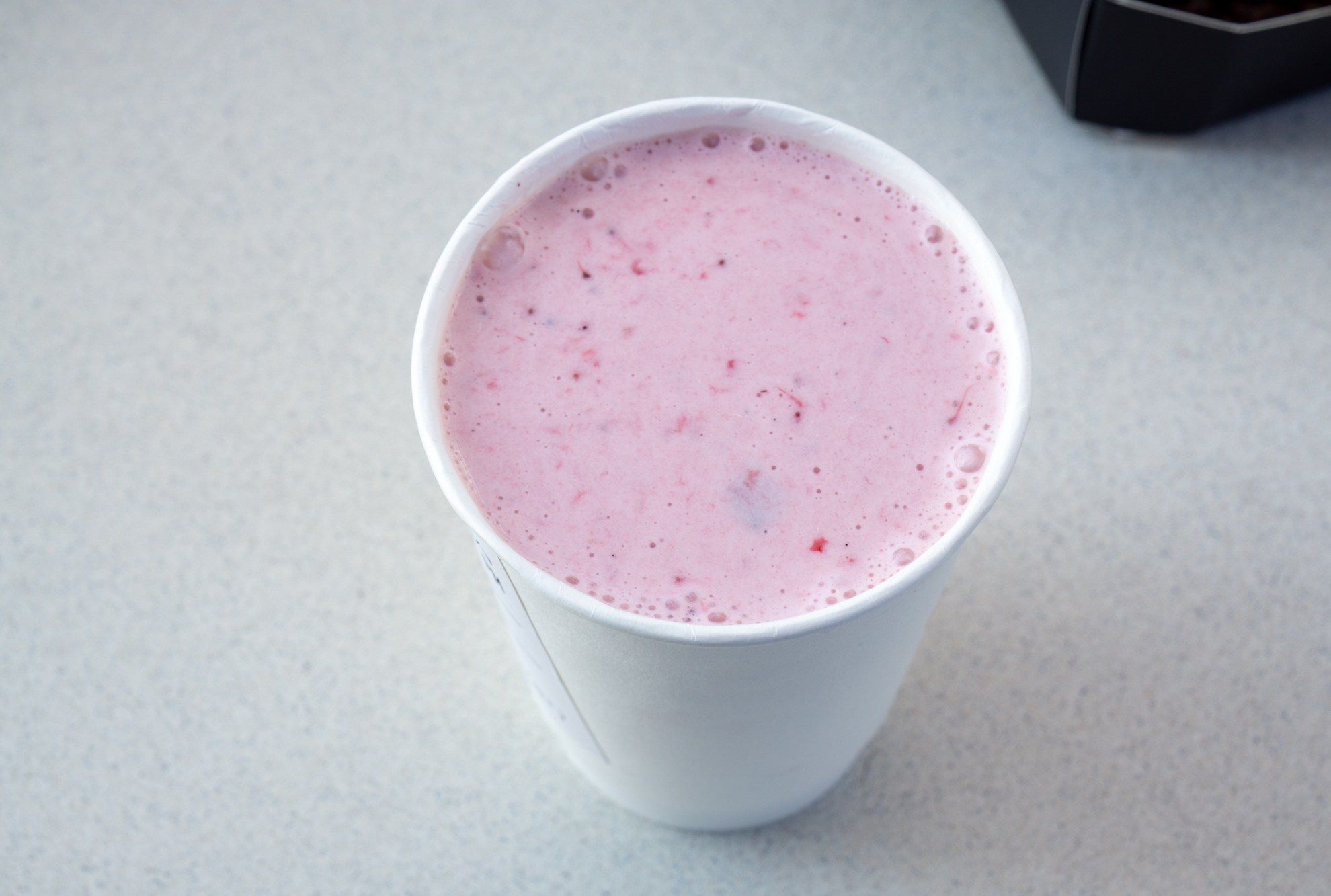 Strawberry shake in a paper cup.