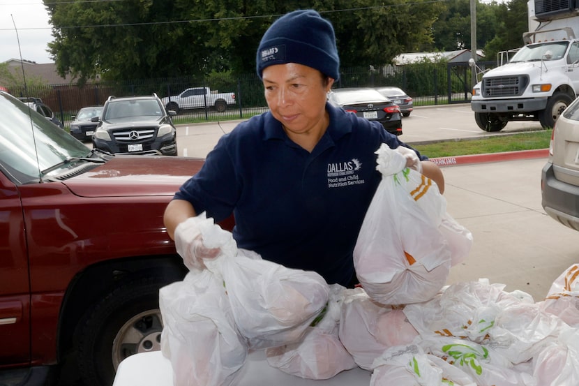 Dallas ISD staff member Delmy Campos picks up bags of food to distribute on July 16, 2025,...