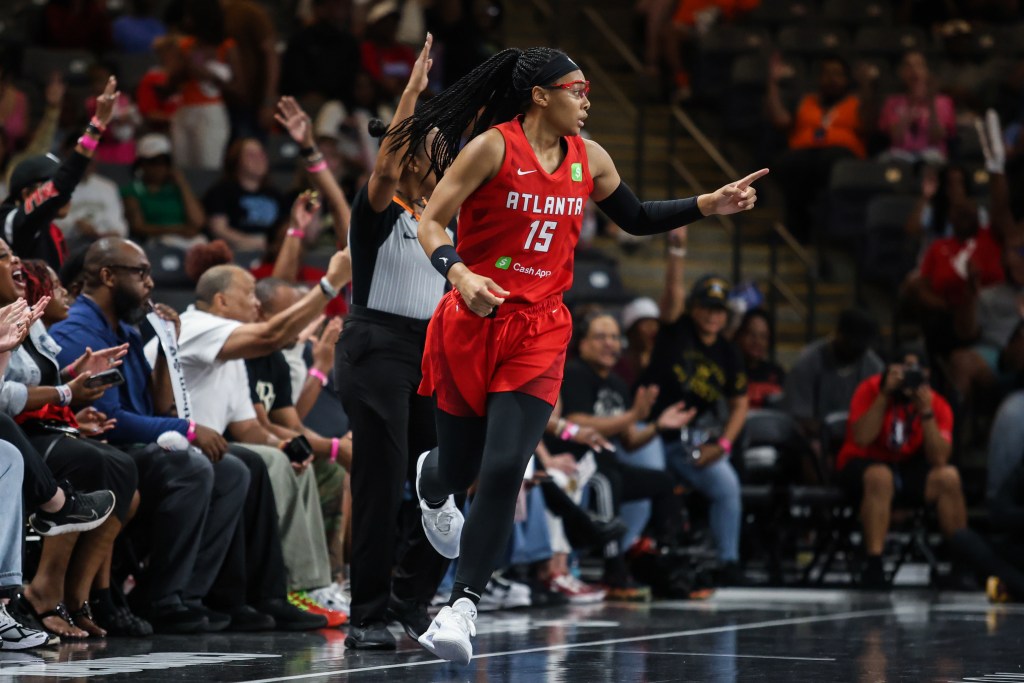 Allisha Gray runs upcourt towards the camera, wearing red sport glasses that match her red Atlanta Dream jersey