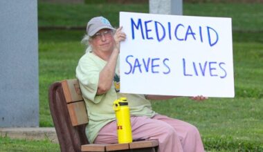 Woman holds placard during "Good Trouble Lives On: Dying for Healthcare" rally, Danville, PA, July 2025