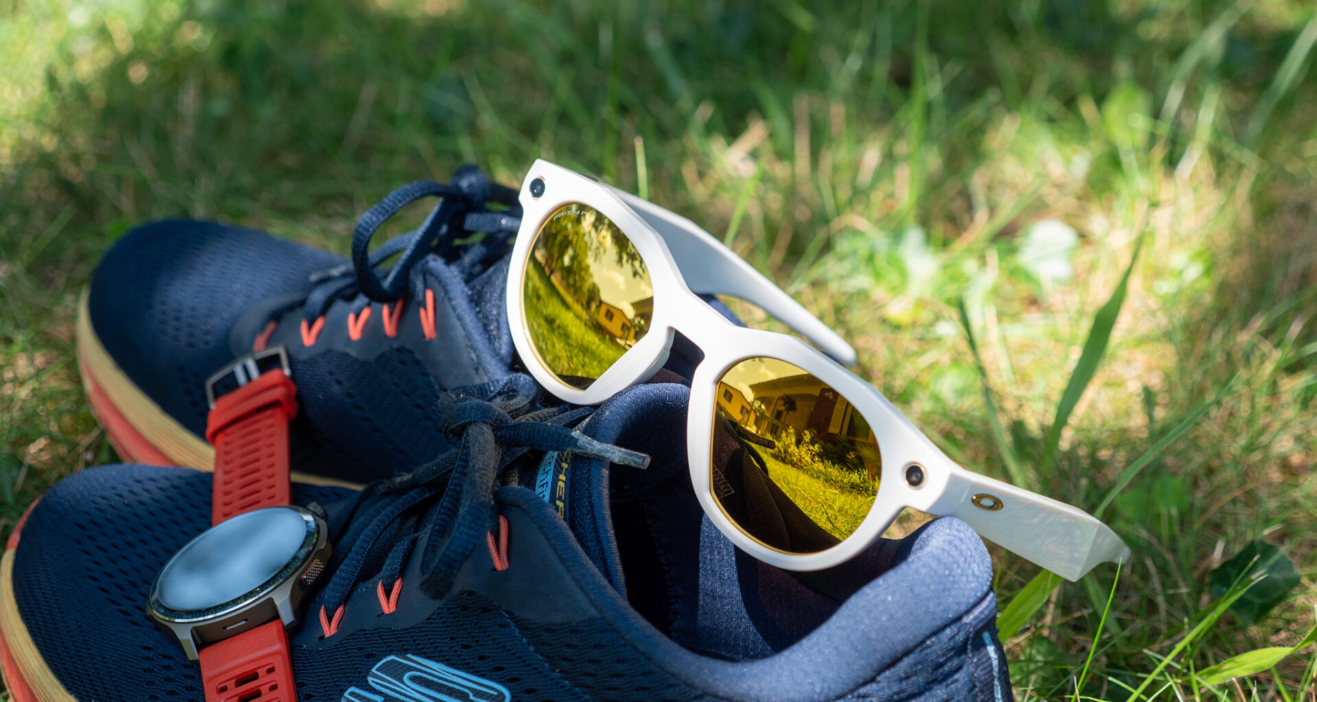 A pair of warm white limited edition Oakley Meta HSTN smart glasses with PRIZM lenses with running shoes and an Amazfit Balance 2 smartwatch