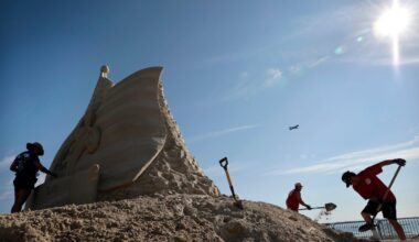 Sculptor Melineige Beauregard, left, worked on, “Revolutions Start Here,” the centerpiece of the 21st annual Revere Beach International Sand Sculpting Festival.