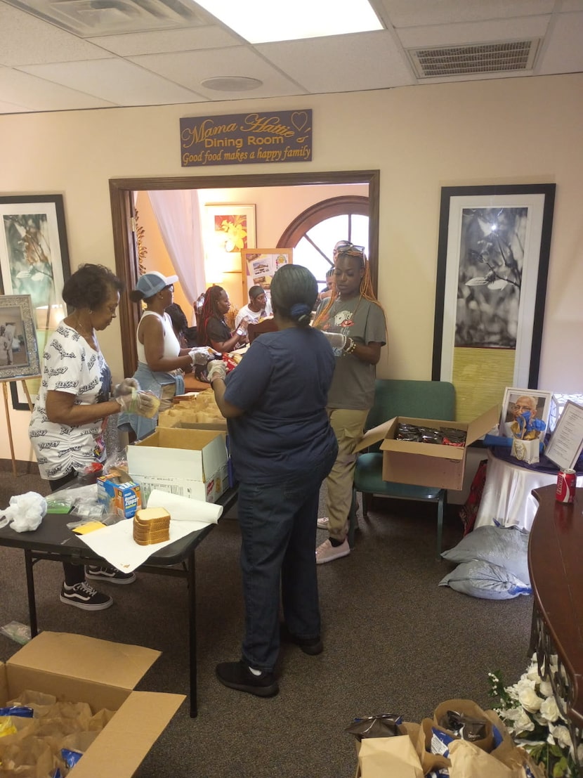 Volunteers from The Rock Church of Dallas in DeSoto prepare sandwiches to deliver behind...
