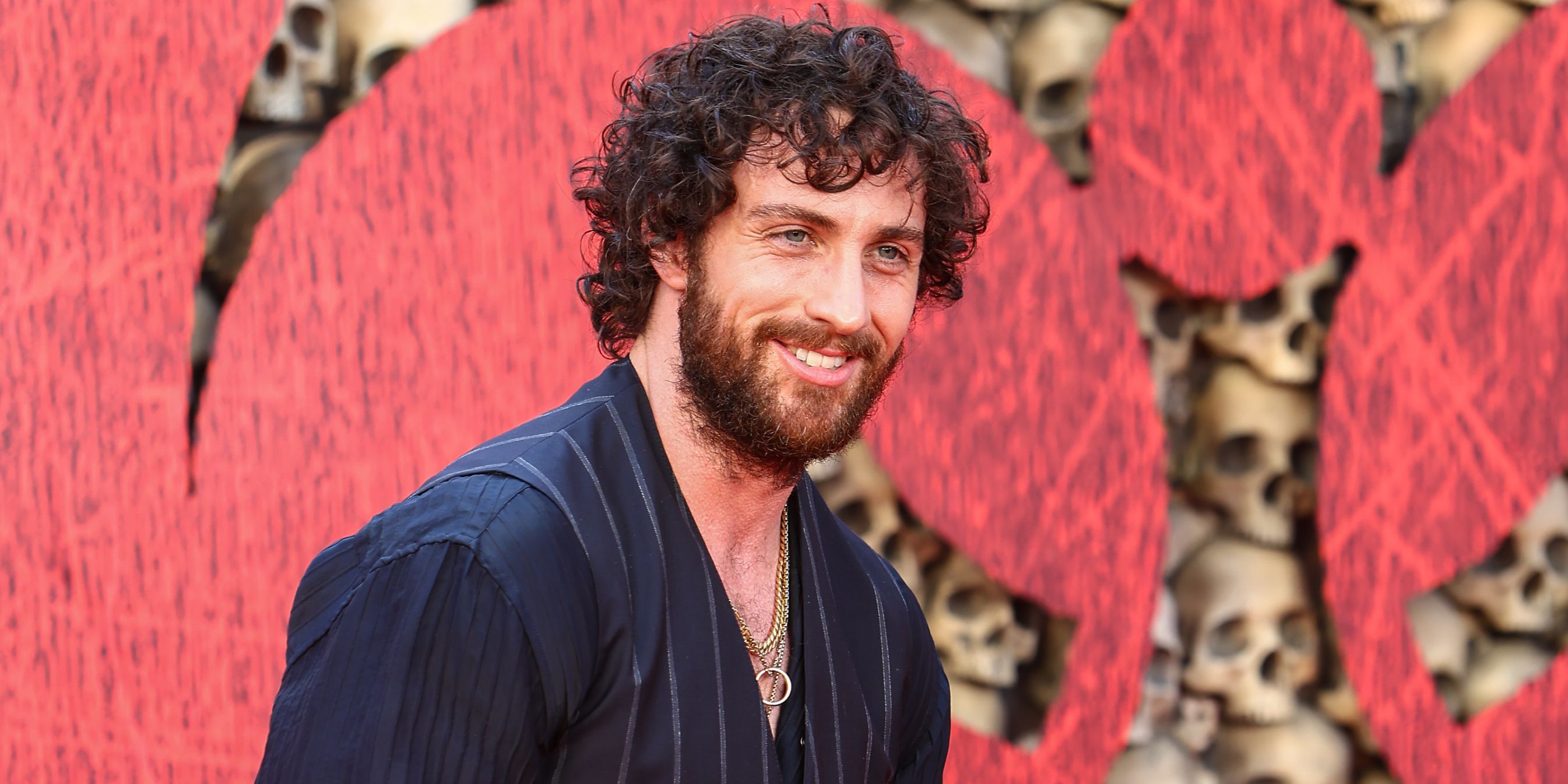 Aaron Taylor-Johnson smiling on the red carpet for 28 Years Later