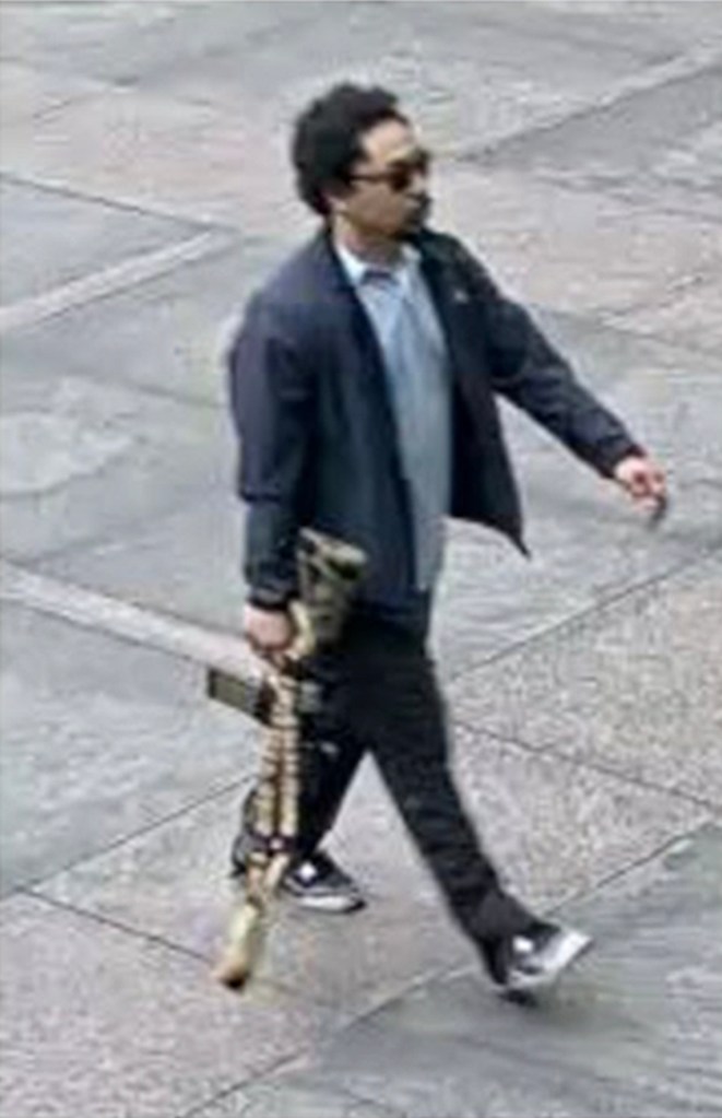 Surveillance image of a man carrying a rifle.