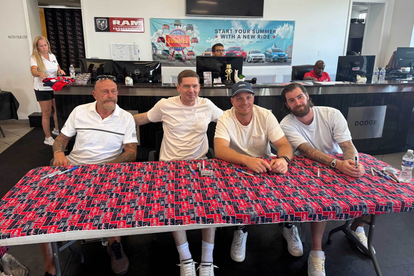 Al Iafrate, Evgeny Kuznetsov, John Carlson, and Logan Thompson pose for a photo