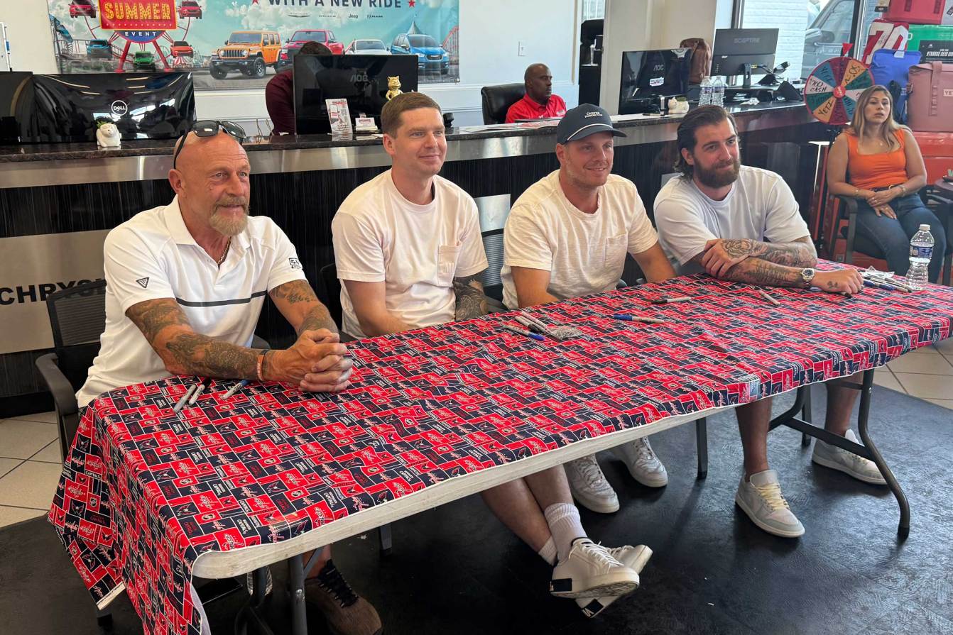 Al Iafrate, Evgeny Kuznetsov, John Carlson, and Logan Thompson pose for a photo