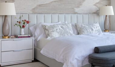 Light, airy bedroom featuring an oversized channel tufted headboard flanked by two nightstands with glossy-based table lamps.