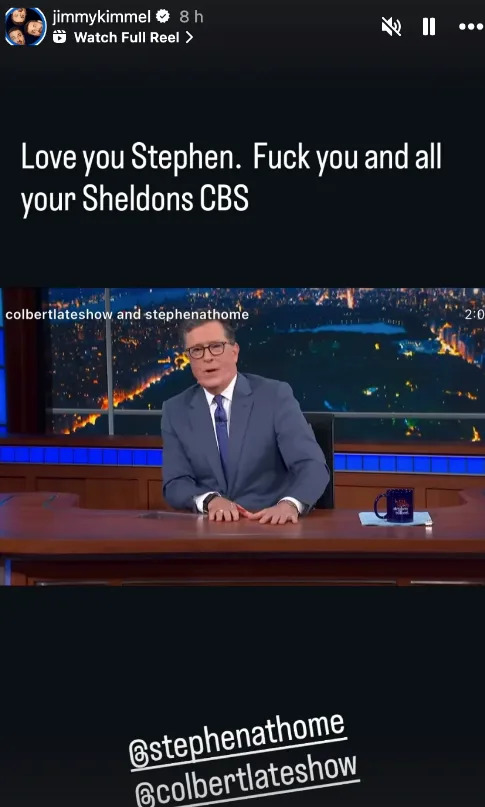 Stephen Colbert sits at a desk on a talk show set, wearing a suit and tie, with text above expressing a humorous message directed at CBS