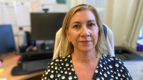 Head teacher Jayne McLaren sitting in front of her computer