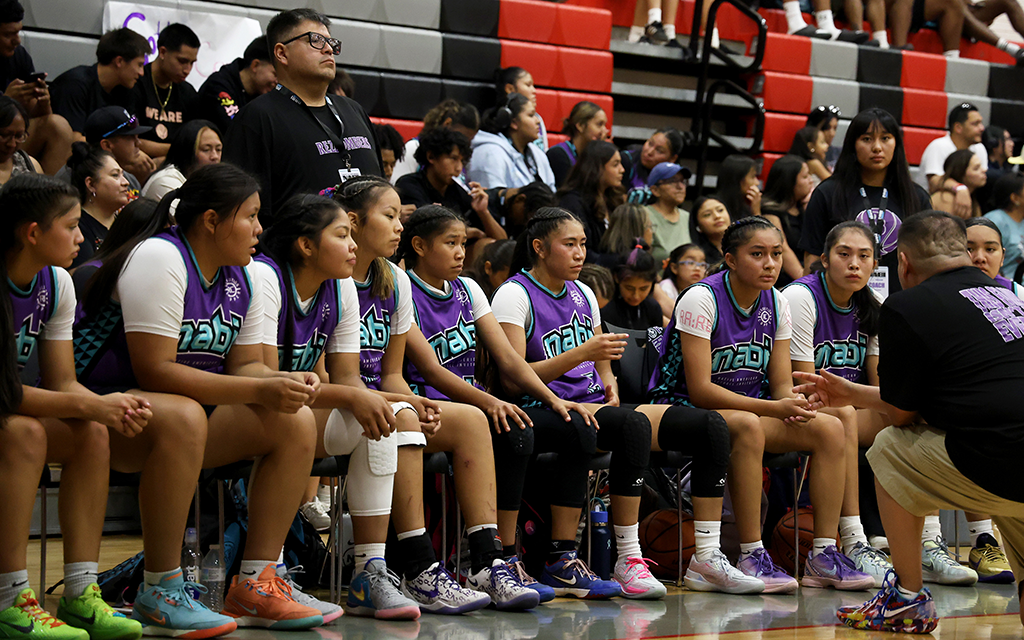 Coach Brian Kaye addresses his team on the bench.