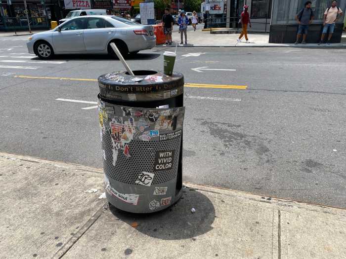 a public garbage can vandalized with graffiti 