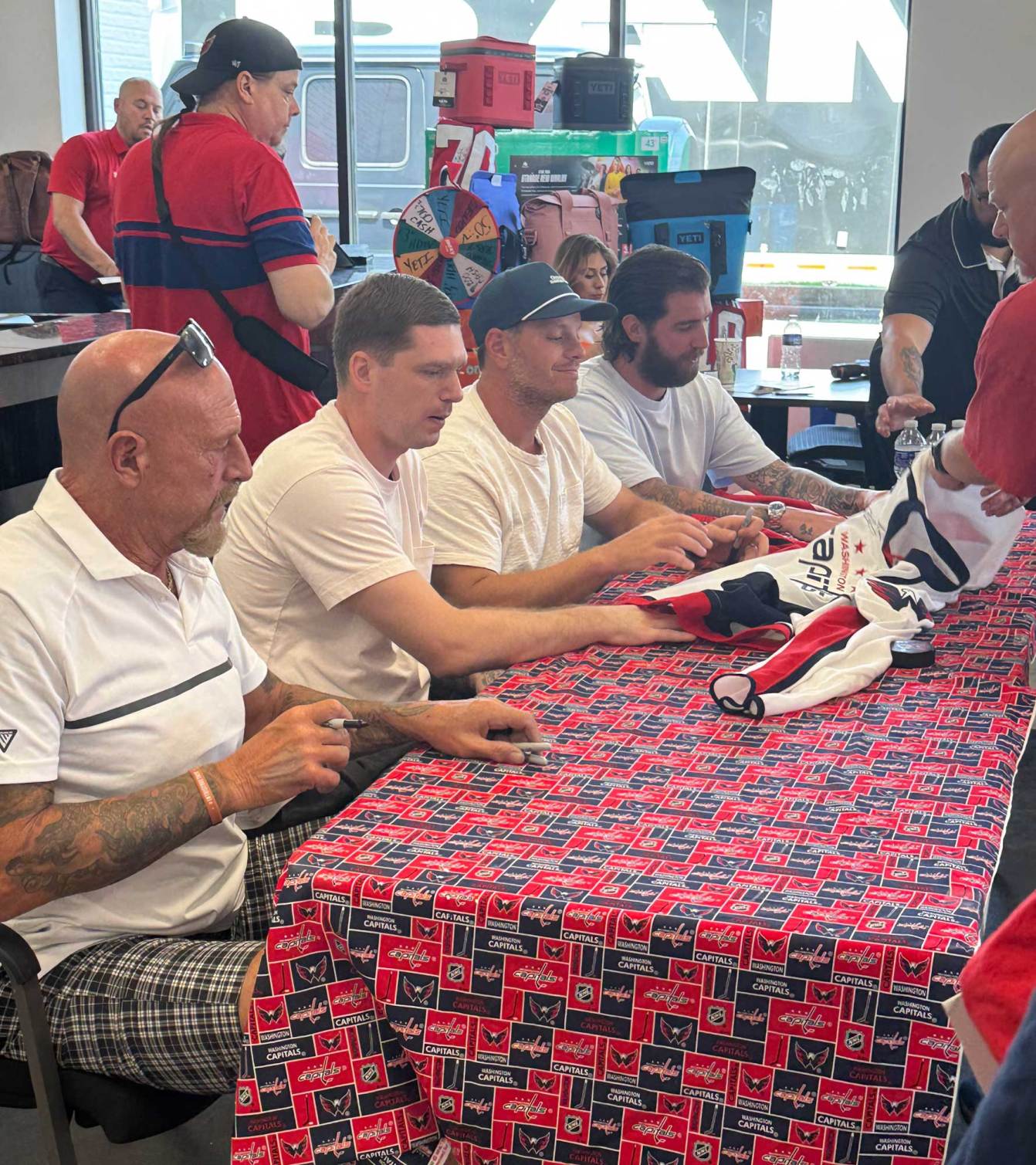 Al Iafrate, Evgeny Kuznetsov, John Carlson, and Logan Thompson sign autographs for fans