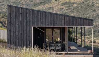 pitched roof tops linear casa las tupas, clad in charred timber in northern chile