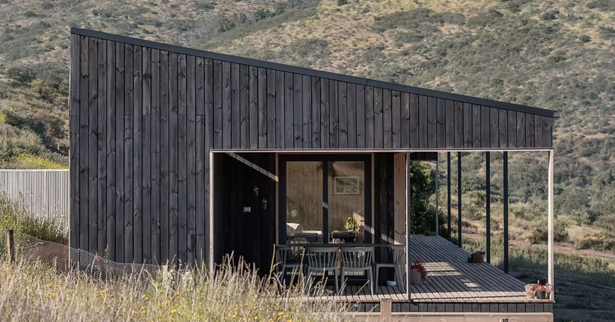 pitched roof tops linear casa las tupas, clad in charred timber in northern chile