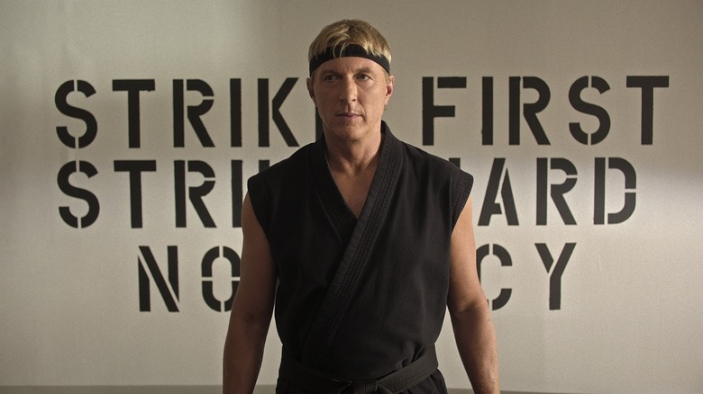 William Zabka's Johnny Lawrence standing in front of his dojo in Cobra Kai