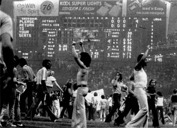 The scoreboard message at Comiskey Park goes unheeded as thousands of spectators engulf the field during an anti-disco demonstration that caused the second game of a double-header to be called off. Detroit won the opener 4-1. (Hank George/UPI)