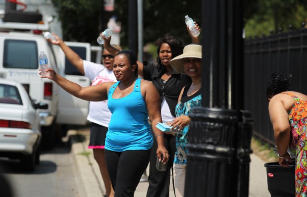 Lavonne Mills, front in blue top, and other members of St. Sabina Catholic Church give out free water on the corner of Racine Avenue and 79th Street on July 6, 2012. (Abel Uribe/Chicago Tribune)