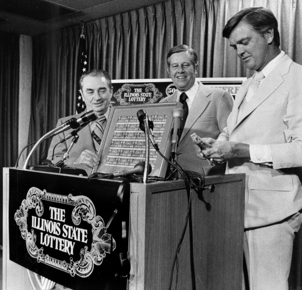 Gov. Dan Walker, right, counts out $12 dollars as he buys the first 24 lottery tickets printed for the Illinois State Lottery. Joining Walker is lottery Superintendent Ralph Batch and Director of Revenue Robert Allphin on Aug. 6, 1974. (Lynette Miller/Chicago Tribune)