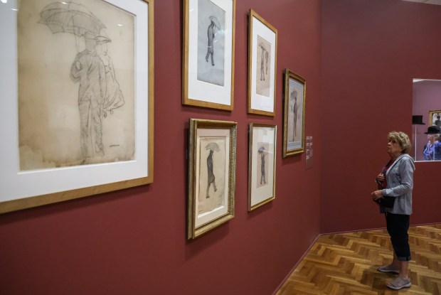 A woman looks at the studies for "Paris Street; Rainy Day" in the Art Institute of Chicago's "Gustave Caillebotte: Painting His World" exhibit at the Art Institute of Chicago on July 24, 2025. (Dominic Di Palermo/Chicago Tribune)