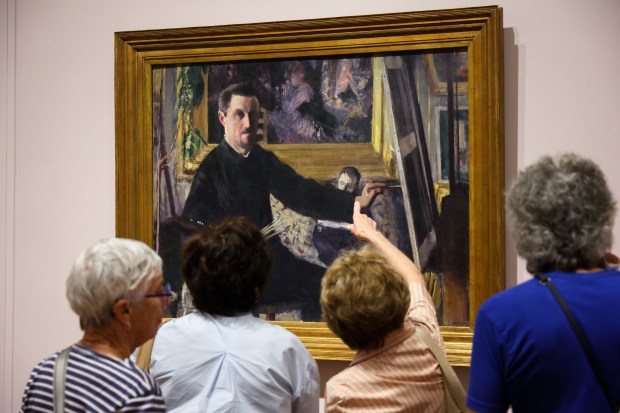 Guests study the "Self-Portrait with an Easel" painting in the Art Institute of Chicago's "Gustave Caillebotte: Painting His World" exhibit on July 24, 2025. (Dominic Di Palermo/Chicago Tribune)
