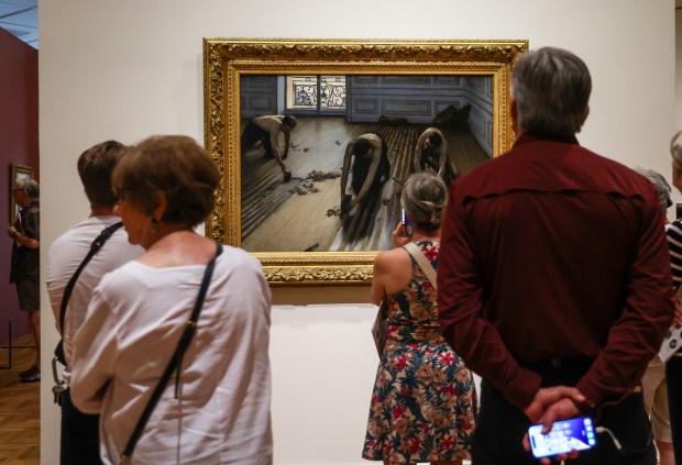 People study the "The Floor Scrapers" painting in the Art Institute of Chicago's "Gustave Caillebotte: Painting His World" exhibit on July 24, 2025. (Dominic Di Palermo/Chicago Tribune)