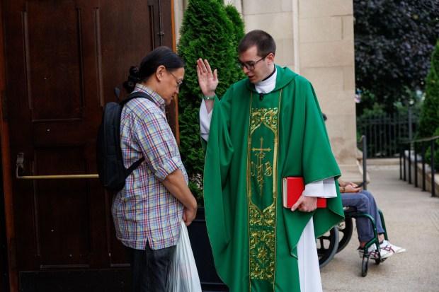 The Rev. Andy Matijevic blesses Valentino Zubiri after an LGBTQ outreach mass at Our Lady of Mount Carmel Church on July 13, 2025, in Chicago. (Armando L. Sanchez/Chicago Tribune)