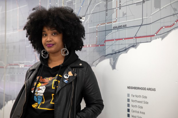 Tonika Johnson stands in front of her work, "The Folded Map" project, which compares North Side addresses with their South Side equivalent, at Englewood Branded on Nov. 6, 2019. (Erin Hooley/Chicago Tribune)