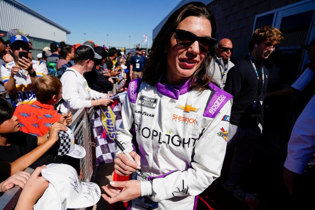 Katherine Legge signs autographs before a NASCAR Cup Series race March 9, 2025, at Phoenix Raceway in Avondale, Ariz. (AP Photo/Darryl Webb)