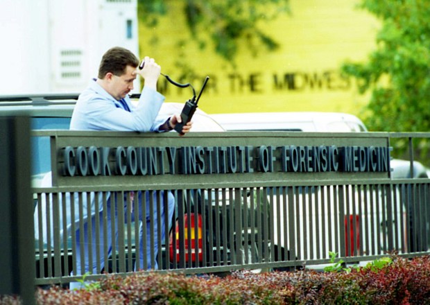 The scene in the parking lot of the Cook County Institute of Forensic Medicine as police wagons arrive to drop off the bodies of those who had died in the heat wave on July 17, 1995. The bodies were kept in refrigerated trucks until they could be processed in the morgue. (Jose More/Chicago Tribune)